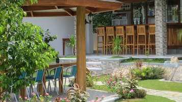 A patio area with outdoor seating, a bar, and a stone pathway.