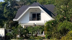 A two-story house with a swimming pool, surrounded by lush greenery and a well-maintained garden. - Garden Bungalows Resort (Siquijor)