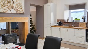Una cocina moderna con armarios blancos, encimera de madera y estufa integrada.