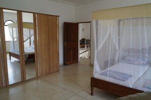 Una camera da letto con un letto, un armadio e una porta che dà su un'altra stanza.