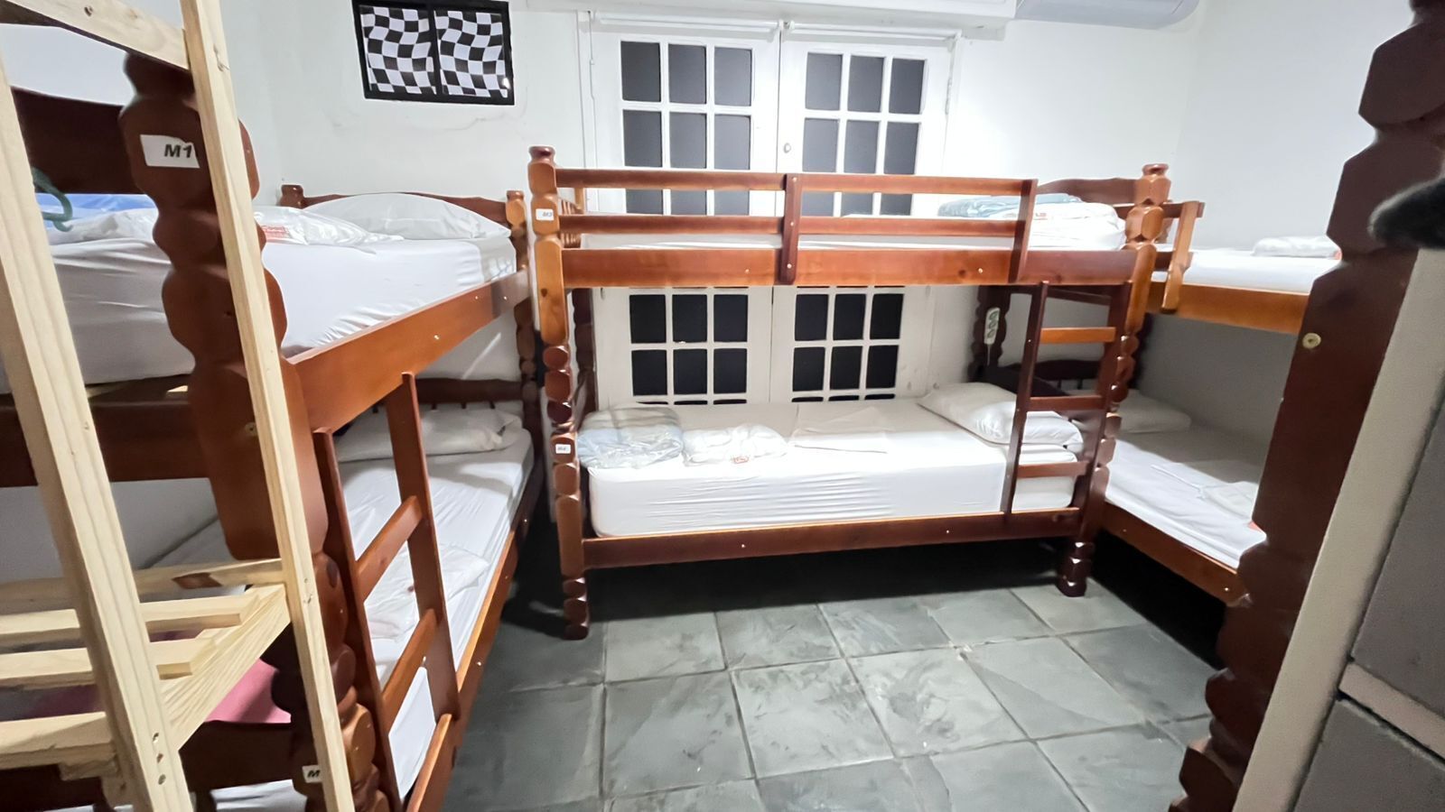 A bunk bed room with a window and a checkered wall decoration.