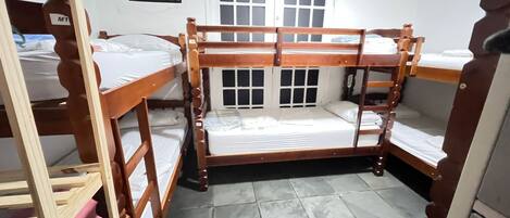 A bunk bed room with a window and a checkered wall decoration.