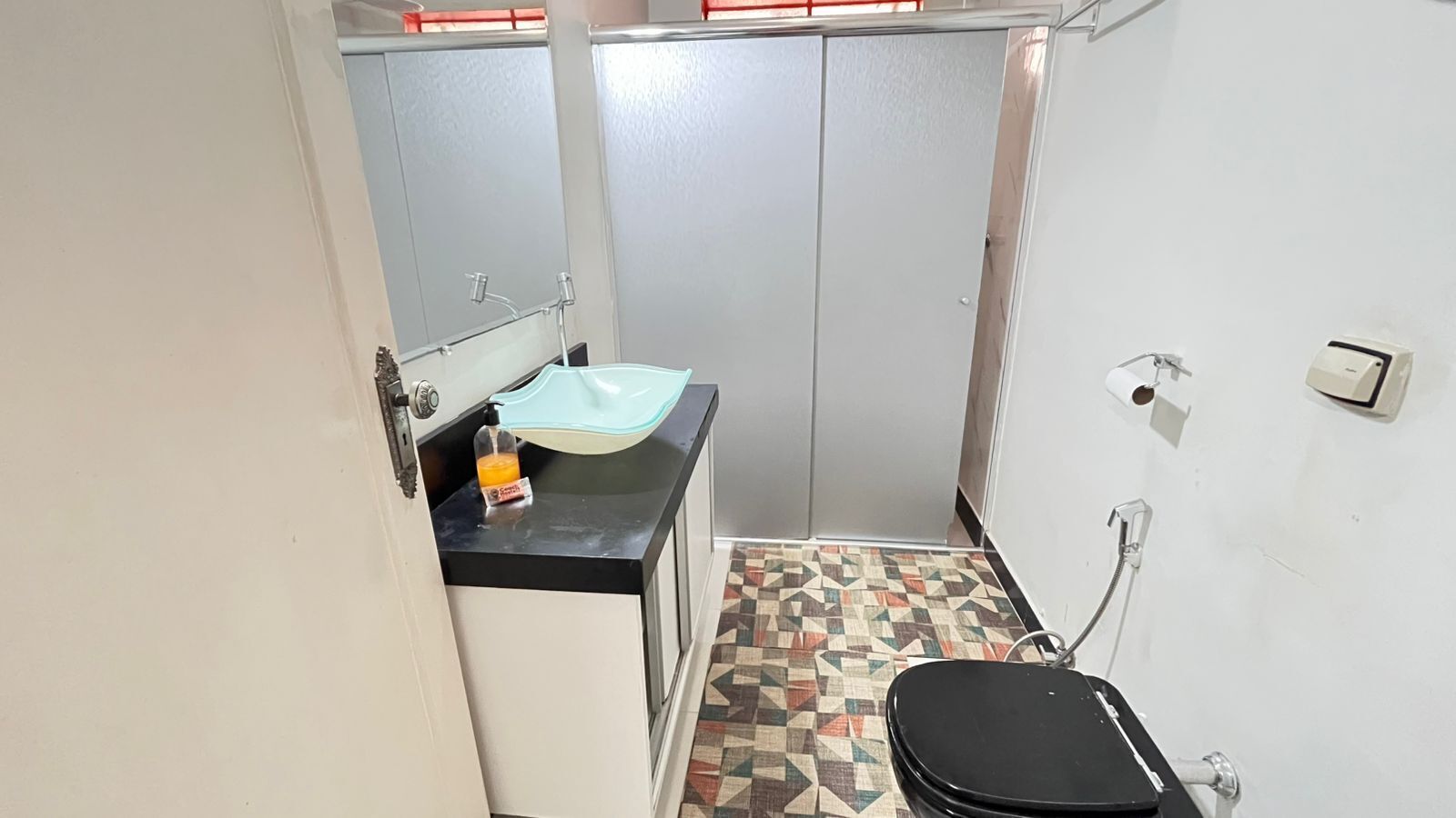 A small bathroom with a sink, toilet, and shower.