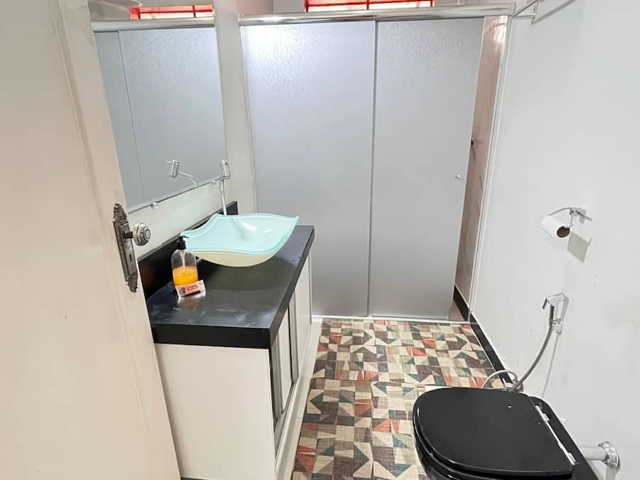 A small bathroom with a sink, toilet, and shower.