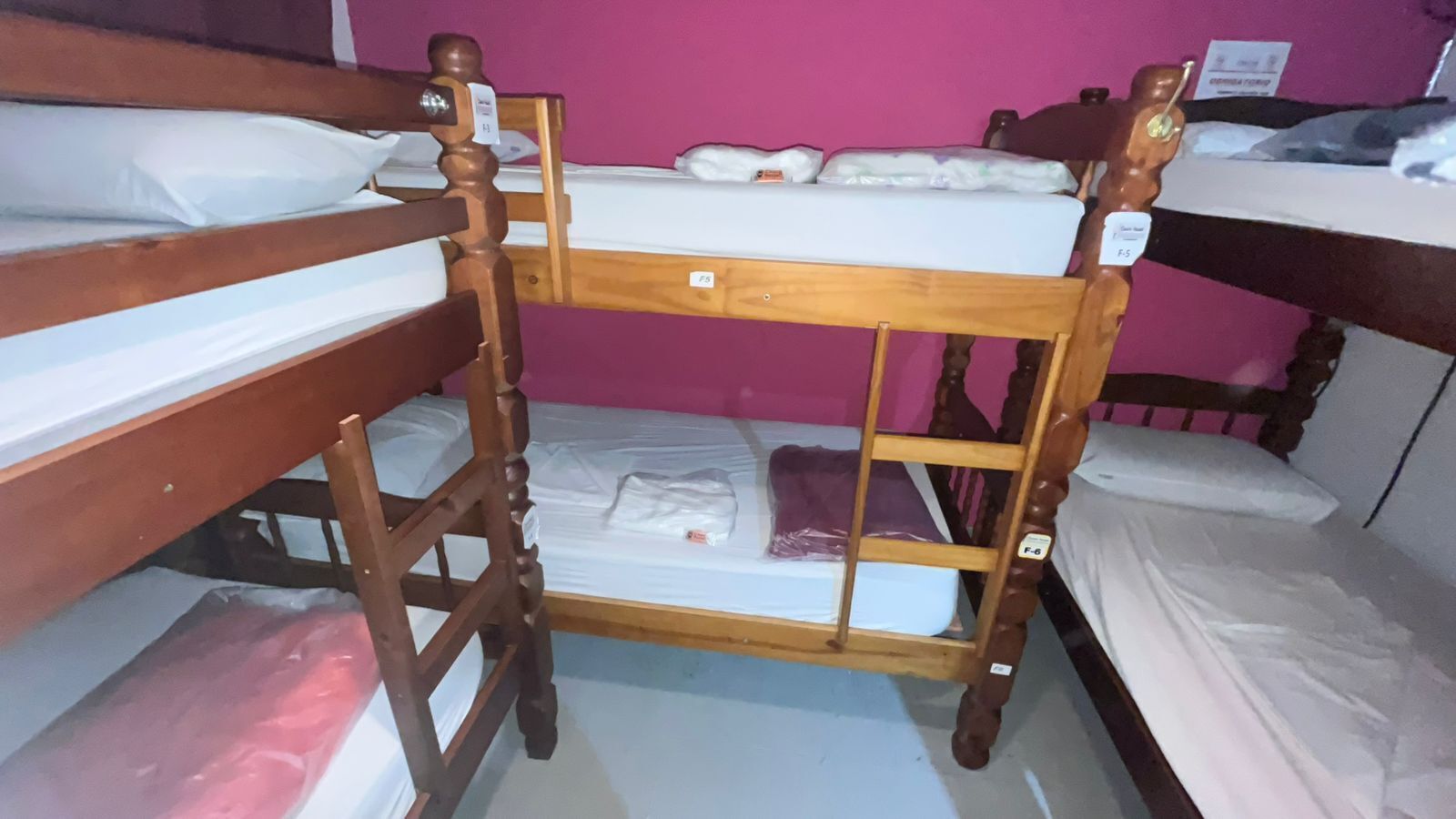 Dormitorio con literas de madera y ropa de cama blanca.