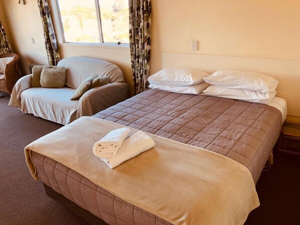 A hotel room with two beds, a sofa, and a window with curtains. - Two Bedroom Family Unit, with Sea View and 5 beds (Ostend)