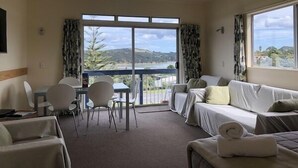 Une chambre d’hôtel avec un balcon, un coin repas et un lit.