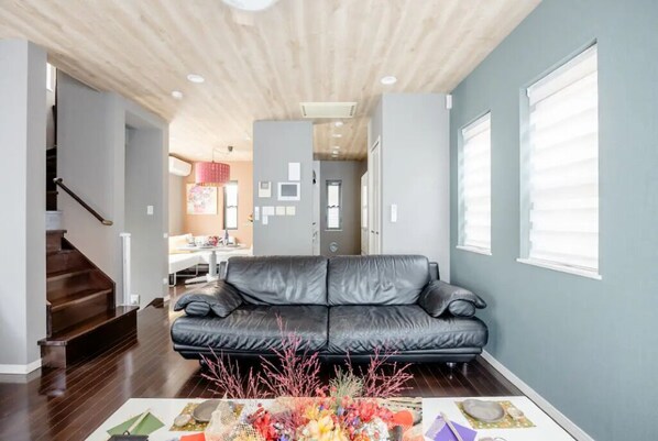 Relax in this stylish living room with a comfortable sofa, decorative vase, and natural light pouring in through the large window.