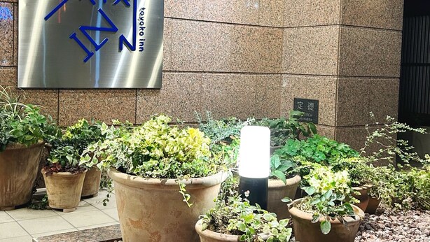 A hotel entrance with a large sign in a foreign language, potted plants, and a tiled floor. - Toyoko Inn Omori (Tokyo)