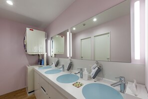 A bathroom with three sinks, a mirror, and a heater. - plat hostel keikyu haneda home (Tokyo)
