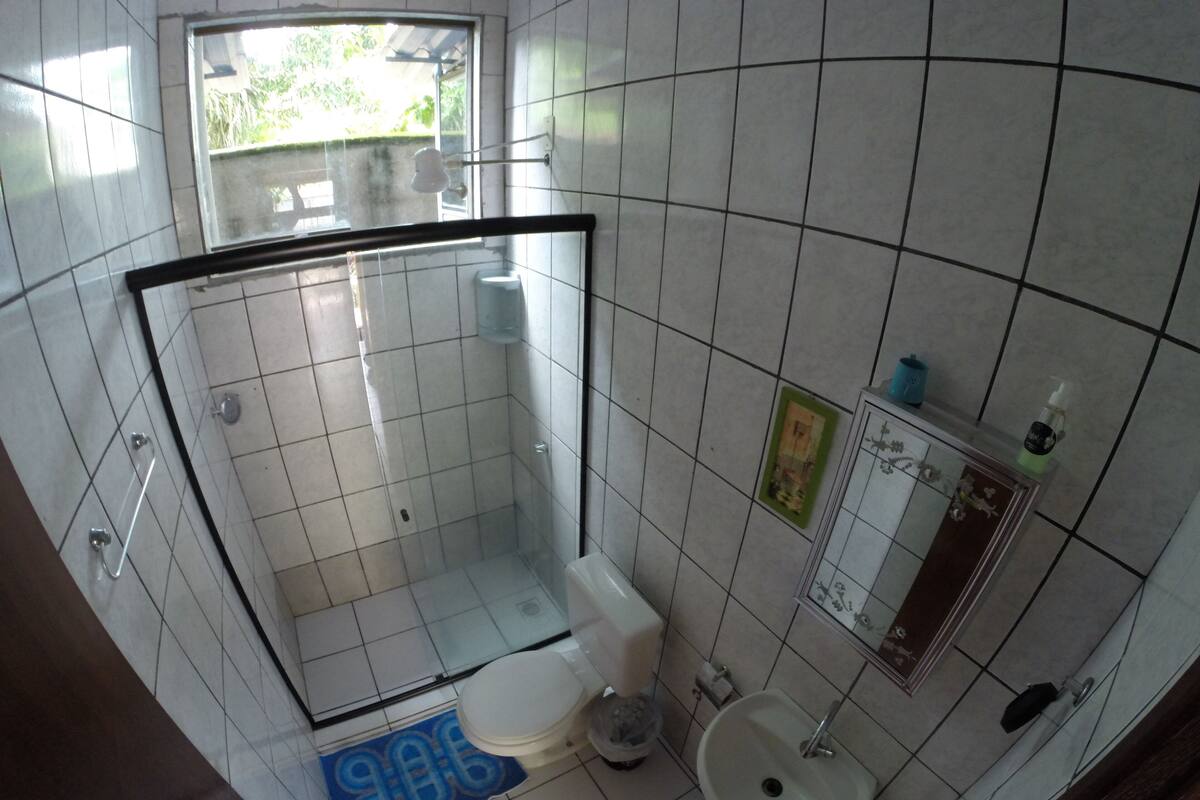 A small bathroom with a toilet, sink, and shower.
