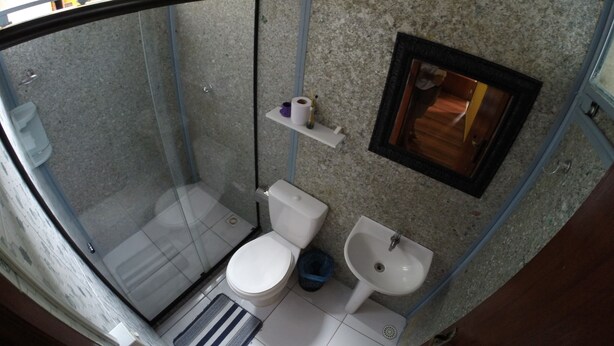 Un bany compacte amb plat de dutxa de vidre, vàter, bidet i rentapel.