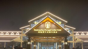 The exterior of the Sealong Bay Zhongqi Conifer Hotel with illuminated signage and a modern architectural design. - Sealong Bay ZhongQi Conifer Hotel (Prey Nob)