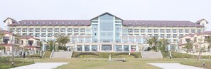 A large hotel with multiple floors, a central glass facade, and a symmetrical design. - Sealong Bay ZhongQi Conifer Hotel (Prey Nob)