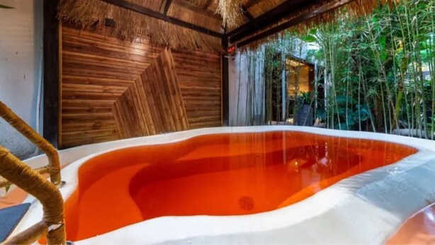 A hot tub with a wooden interior and a thatched roof. - Floral Hotel Yun Jing He Yuan Haidong (Haidong)
