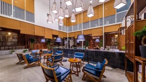 A spacious indoor area with multiple seating arrangements, including chairs and tables, and a counter area with a tiled backsplash. - Floral Hotel Yun Jing He Yuan Haidong (Haidong)