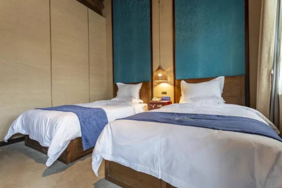 A double bed with a wooden headboard and a bedside table with a lamp.
