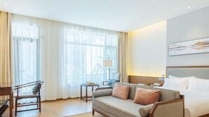Una habitación de hotel con sofá, cama, escritorio y una silla.