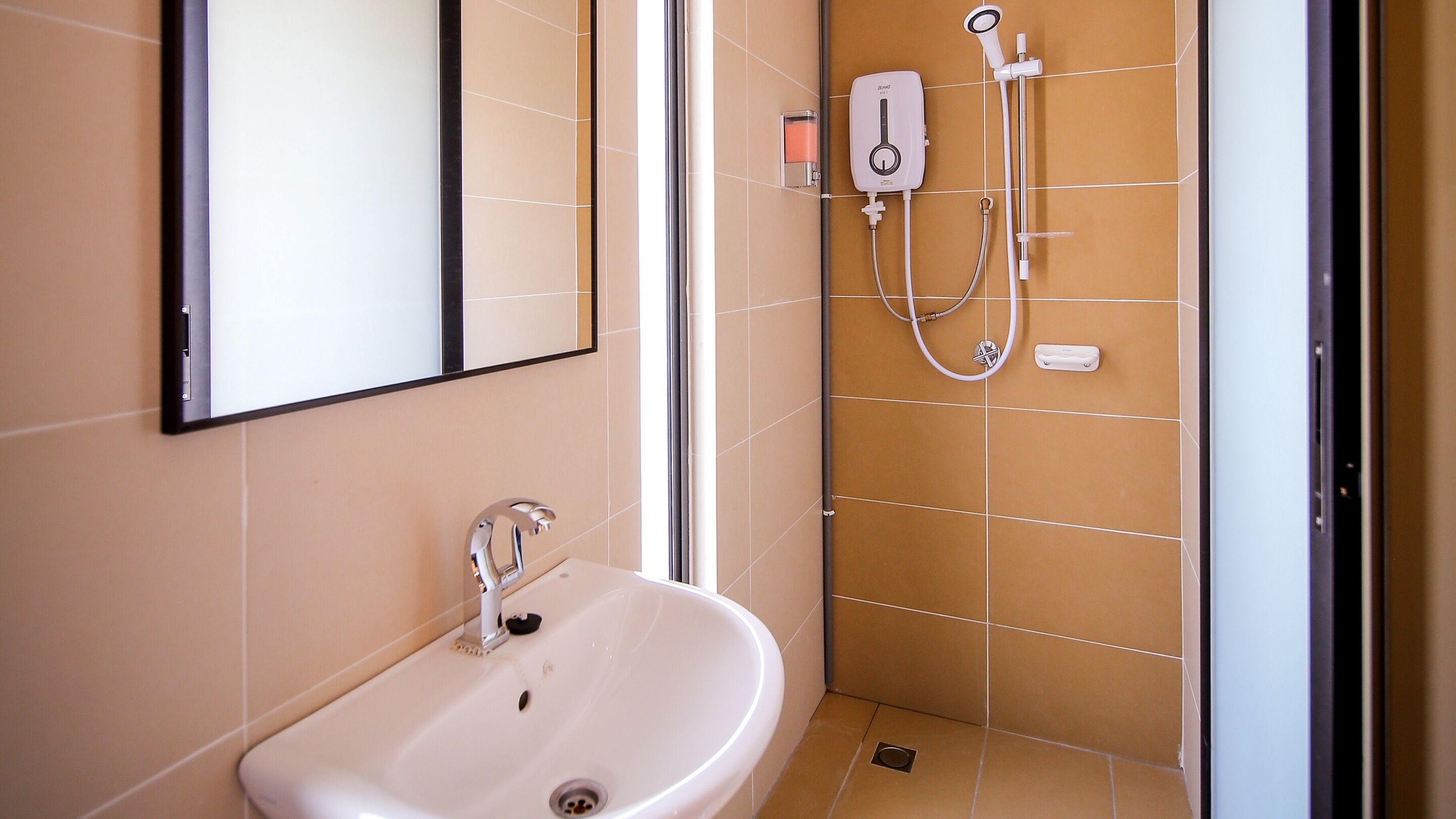 Baño con lavamanos, espejo y ducha.