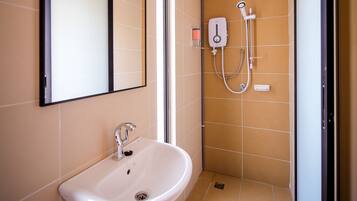 Baño con lavamanos, espejo y ducha.