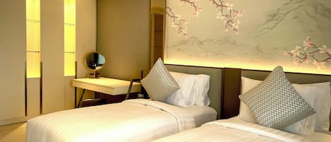 Una habitación de hotel con dos camas, un escritorio con espejo y una pared con un mural floral.
