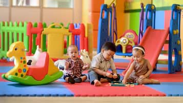 Children playing with toys on a colorful play mat.