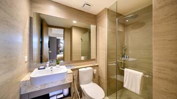 A modern bathroom with a glass-enclosed shower, a large mirror, and a vanity with a sink and toilet.