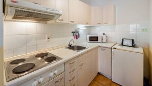 Una cocina moderna con armarios blancos, estufa, microondas y tostadora.
