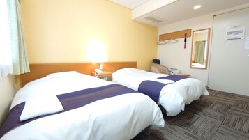 A hotel room with two beds, a nightstand with a lamp, a chair, a desk with a printer, and a mirror on the wall.