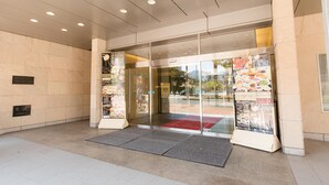 Ein Hotel Eingang mit Glastür, rotem Teppich und einer Speisekarte außen.