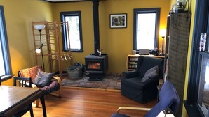 Un salon chaleureux avec une cheminée, des meubles en bois et une vue agréable par les fenêtres.