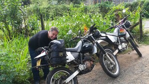 A man leaning on a dirt path next to a motorcycle with a sidecar. - Tiny Holiday Resort (Dambulla)