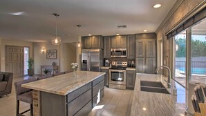 A modern kitchen with a large island, stainless steel appliances, and a view to the outside. - Poolside Relaxation: Upscale Gem 3 Mi to Old Town! (Scottsdale)