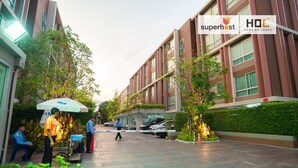 Un edificio moderno con un cartel que dice 'superhost' y 'HOC HOME ON CONDO'.