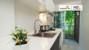 Una cocina moderna con un lavamanos de acero inoxidable, una tetera y una planta en maceta.