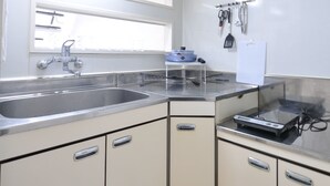 Una cocina compacta con un lavamanos, estufa y armarios.