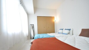 Ein Hotelzimmer mit einem Bett, einem Kleiderschrank, einem Nachttisch und einem Spiegel.