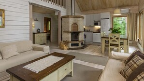 Een knus chaletinterieur met een open haard, houten vloeren en een eethoek.
