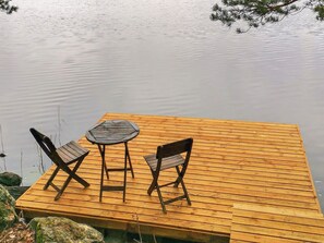 Un muelle de madera con una mesa y dos sillas.