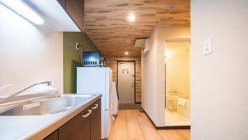 Una cocina moderna con un lavamanos de acero inoxidable, armarios de madera y un refrigerador empotrado.