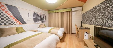 A hotel room with two beds, a desk, a TV, and a wall with a checkered pattern and a floral design.