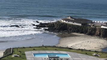 A coastal property with a swimming pool, beach access, and ocean views.