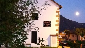 Een wit gebouw met een bord waarop staat: ALBERGO TURISTICO EL CORDO DE LACIANA.