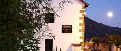 A white building with a sign that reads "ALBERGO TURISTICO EL CORDO DE LACIANA".