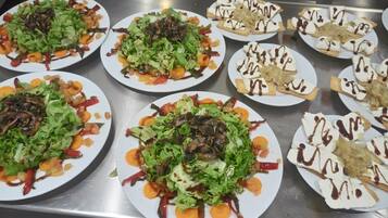 A buffet with various dishes including salads, vegetables, and desserts.