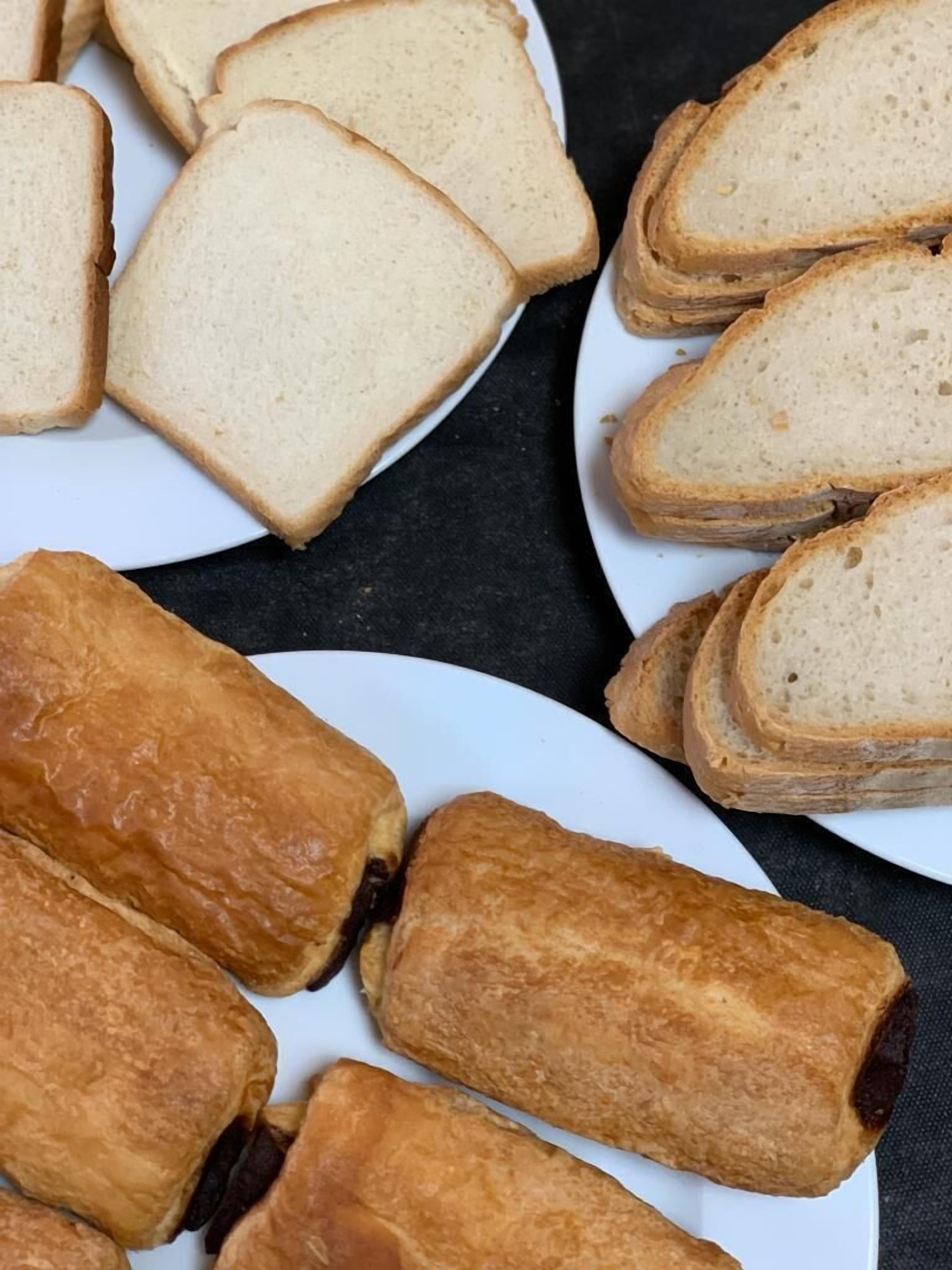 Un plat amb llesques de pa blanc i pastissos daurats.