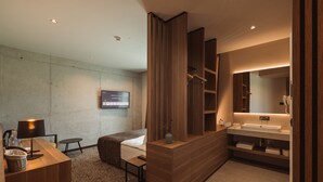 A modern bathroom with a wooden vanity, a large mirror, and a built-in shower area. - Hotel Grof (Vransko)