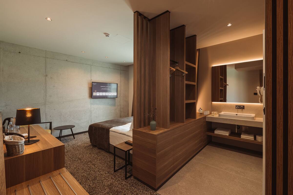 A modern bathroom with a wooden vanity, a large mirror, and a built-in shower area.