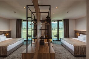 A hotel room with two beds, a central wooden structure, and a view of the outdoors. - Hotel Grof (Vransko)