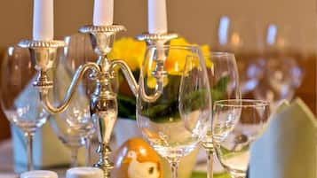 A table set for a meal with white candles, clear glassware, and a decorative egg.